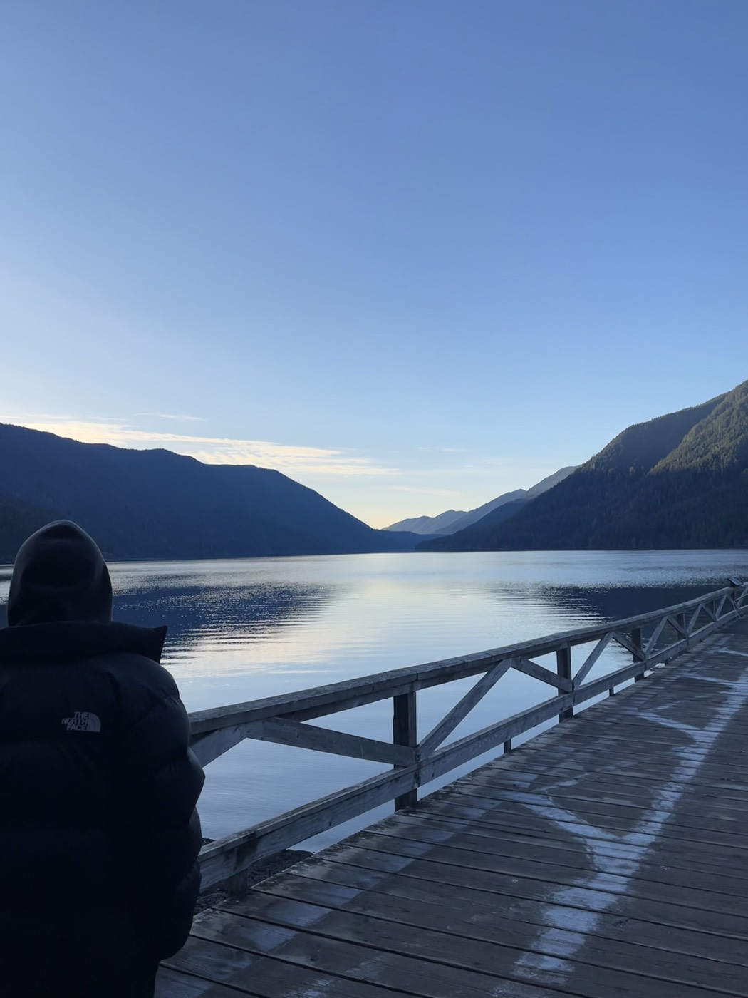 Looking down a wooden dock over Crescent Lake at sunrise